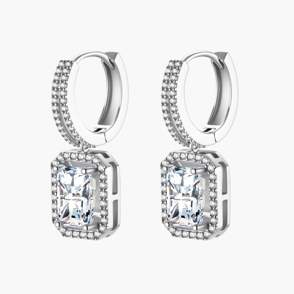 Sterling silver huggie hoops with emerald-cut moissanite drops featuring pavé-set crystals on white background.
