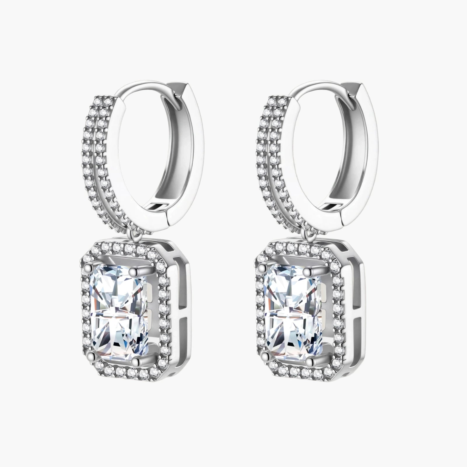 Sterling silver huggie hoops with emerald-cut moissanite drops featuring pavé-set crystals on white background.